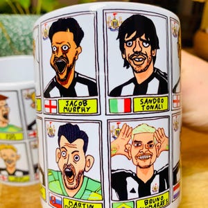Puede incluir: Taza de cer&aacute;mica blanca con ilustraciones de dibujos animados de jugadores de f&uacute;tbol. Cada jugador lleva un uniforme de f&uacute;tbol blanco y negro y tiene una bandera que representa su pa&iacute;s de origen. El texto en la taza dice "Jacob Murphy", "Sandro Tonali", "Martin Dubravka" y "Bruno Guimaraes".