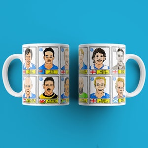 Könnte beinhalten: Zwei weiße Tassen mit einem blauen und gelben Design, das Comicbilder von berühmten Fußballspielern zeigt. Die Tassen haben die Namen der Spieler unter ihren Bildern gedruckt. Zu den Spielern gehören: Rick Davis, Tim Cahill, Duncan Ferguson, Gary Lineker, Paul Gascoigne, Thomas Gravesen, Neville Southall, Phil Neville und Andy Cole.