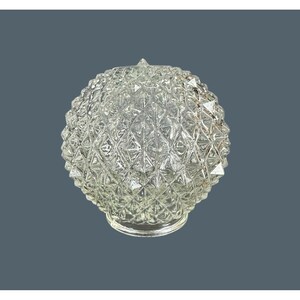 May include: A clear glass light fixture globe featuring a textured, diamond-shaped geometric pattern across its spherical surface. The glass shade has a circular opening at the base, designed for attachment to a lamp or ceiling light fixture.