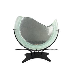 Könnte beinhalten: Dekorative Glasschale mit wellenförmigem Design, getragen von einem schwarzen Metallständer. Die Schale hat einen hellgrünen Farbton und eine strukturierte Oberfläche. Der Ständer hat ein geschwungenes Design. Durchmesser ca. 30 cm.