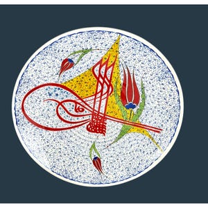 Puede incluir: Un plato de cerámica decorativo con borde blanco y fondo moteado azul. El plato presenta un diseño caligráfico rojo, formas amarillas y verdes e ilustraciones de tulipanes rojos. Una pieza de arte única.