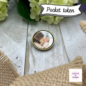 May include: A round wooden token with a gold trim, featuring a photo of a mother and child. The token has the text "LOUIE & PADA" printed on it.