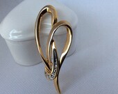 Vintage gold tone with set-in clear rhinestones heart brooch.