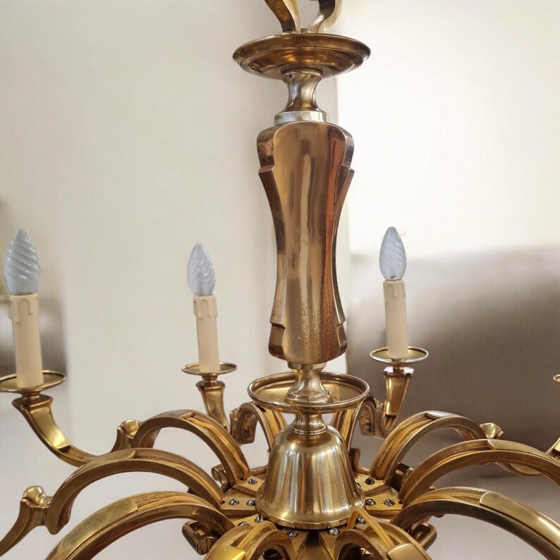 May include: A gold-toned chandelier with multiple arms and candle-style light bulbs. The chandelier has a decorative, ornate design.