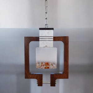 May include: A modern pendant light fixture with a white glass shade and a brown wooden frame. The light is suspended from a silver chain.