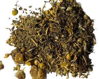 May include: A close-up of a blend of dried herbs and flowers, including chamomile and mint, for making herbal tea.
