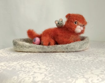 Kitten on a felt mat he has a friend mouse and ball