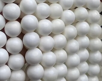 May include: Close-up of a collection of white, spherical beads. The beads are arranged in a grid-like pattern, creating a textured surface. The beads are smooth and have a glossy finish. The image is well-lit, highlighting the round shape of each bead.