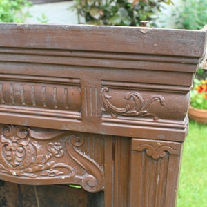 Pu&ograve; includere: Un camino in legno marrone con intagli intricati e un design decorativo. Il camino &egrave; in legno e ha una finitura usurata.
