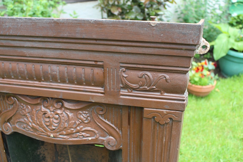 Pu&ograve; includere: Un camino in legno marrone con intagli intricati e un design decorativo. Il camino &egrave; in legno e ha una finitura usurata.