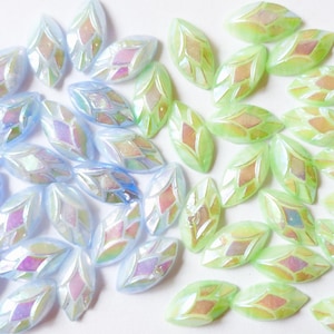 May include: An assortment of iridescent, marquise-shaped beads in two color gradients. The left side features light blue beads, while the right side showcases green beads. Each bead has a diamond-shaped design in the center.