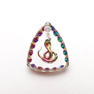 May include: A clear, triangular pendant with a colorful cobra design. The cobra is depicted in shades of red, green, and gold. The pendant is outlined with iridescent beads and has a small hole at the top for a chain.