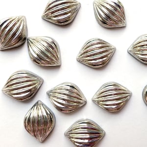 以下が含まれることがあります： 銀色の虹色のファセットカットの涙型のガラスビーズが12個。ビーズはリブ状のテクスチャになっています。