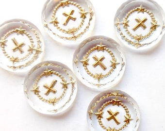 May include: Six clear glass buttons with gold crosses and stars. The buttons are round and have a raised design.