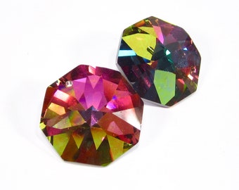 Puede incluir: Dos prismas de cristal octogonales iridiscentes con un agujero en la parte superior para colgar. El prisma de la izquierda es de color rojo intenso con reflejos verdes y dorados. El prisma de la derecha es de color verde intenso con reflejos dorados y azules.