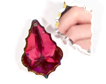 Può includere: Due ciondoli a forma di foglia in cristallo prismatico iridescente. Il ciondolo a sinistra è di colore rosso intenso, mentre il ciondolo a destra è trasparente.