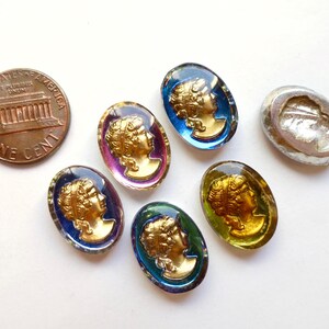 K&ouml;nnte beinhalten: Sechs ovale Glascabochons mit goldenen Folienakzenten, die das Profil einer Frau darstellen. Die Cabochons sind in verschiedenen Farben, darunter Blau, Gr&uuml;n, Lila und Gelb.