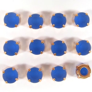 Peut inclure: Douze strass bleus en verre avec des montures dorées. Un strass est dépourvu de verre et montre la monture dorée.