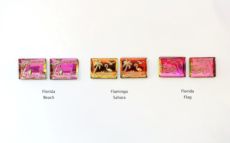 May include: Rectangular, iridescent Florida-themed magnets. Designs include "Florida Beach" with flamingos, "Flamingo Sahara" with palm trees and flamingos, and "Florida Flag" with text. Each magnet has a gold-colored border.