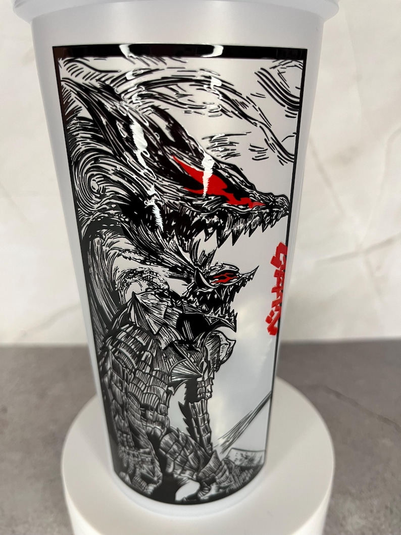 May include: A white plastic tumbler featuring a detailed black and white illustration of a fierce dragon-like creature with red eyes. The design is reminiscent of manga or anime art, with Japanese text on the side.