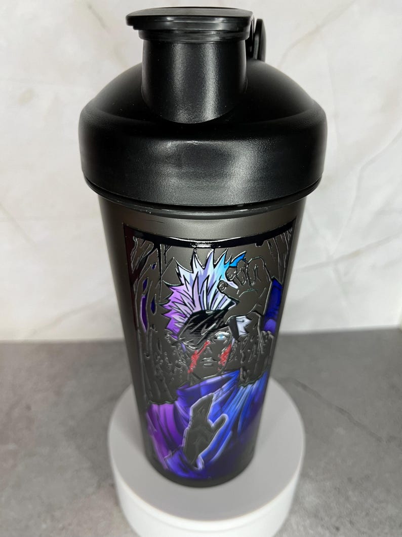 May include: Black shaker bottle with a graphic of a character with white hair and a purple and blue outfit. The character has a red scar on their face.