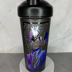 May include: Black shaker bottle with a graphic of an anime character with white hair and a purple and blue outfit. The character has a red scar on their face.