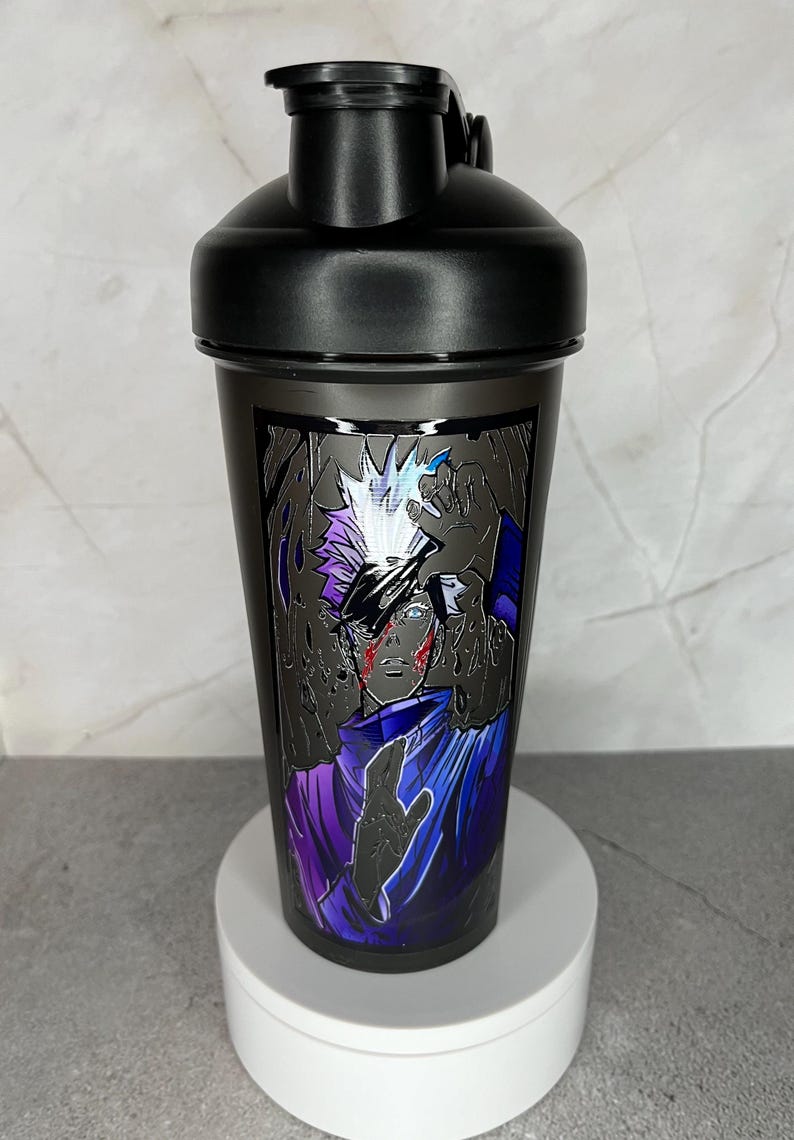 May include: Black shaker bottle with a graphic of an anime character with white hair and a purple and blue outfit. The character has a red scar on their face.