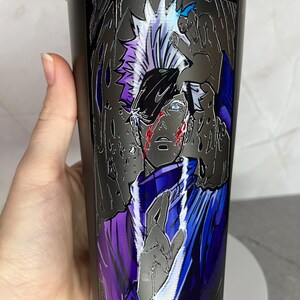May include: A black stainless steel water bottle with a graphic of an anime character with white hair and blue eyes. The character is wearing a purple and blue outfit and has a white outline.
