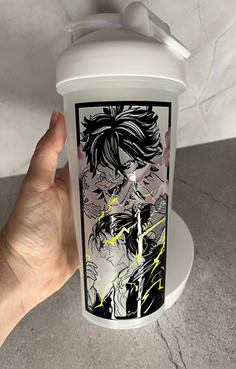May include: White shaker bottle featuring a black and white graphic of anime characters. The characters are surrounded by yellow lightning bolts.