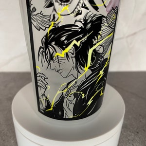 May include: A white ceramic mug featuring a black and white graphic print of an anime character with yellow lightning bolts. The character has black hair and is wearing a black shirt.