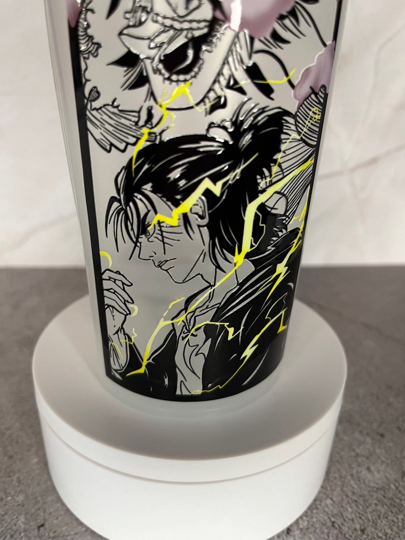 May include: A white ceramic mug featuring a black and white graphic print of an anime character with yellow lightning bolts. The character has black hair and is wearing a black shirt.
