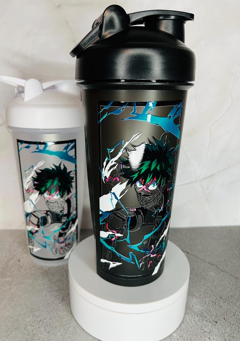May include: Two black and white shaker bottles with a green and white anime character design. The character is in a fighting pose with a black mask and green hair.