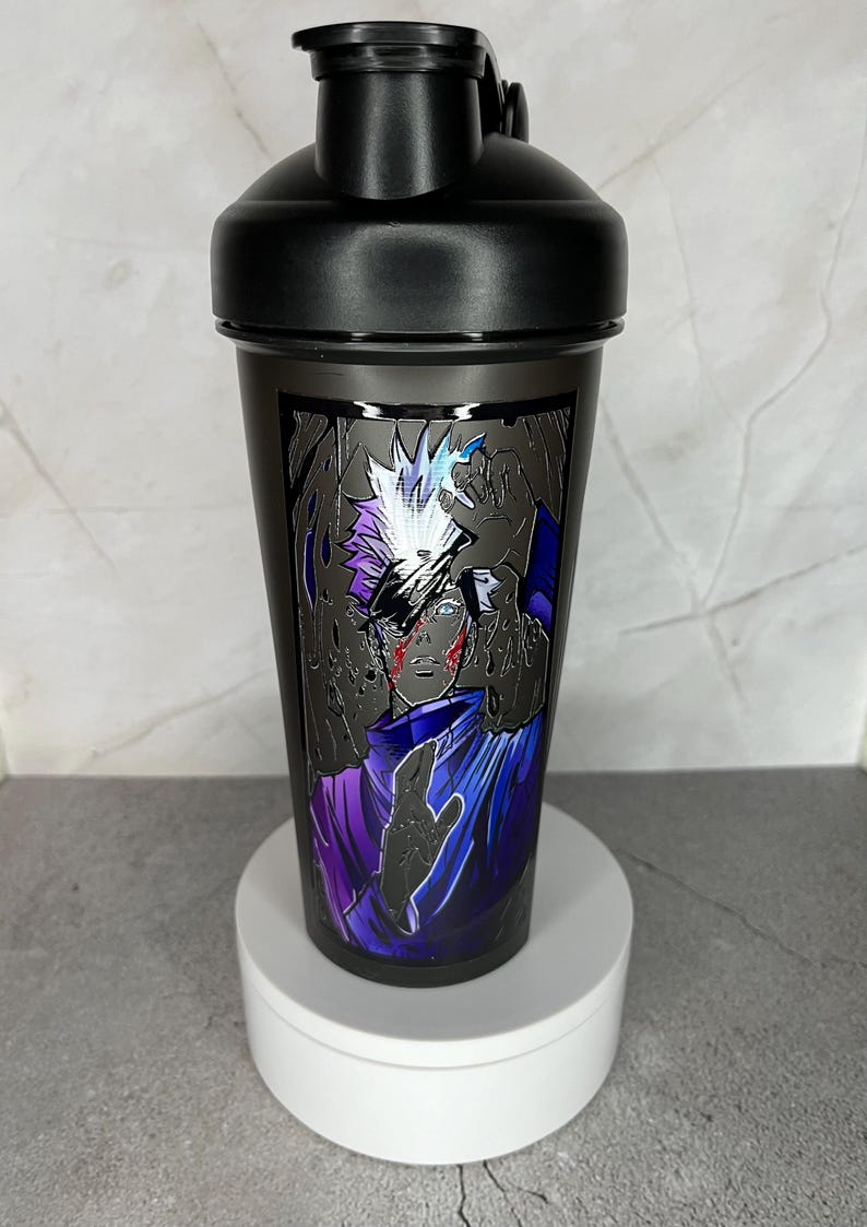 May include: Black shaker bottle with a graphic of a white-haired anime character with a purple and blue outfit. The character has a red mark on their face and is surrounded by black hands.