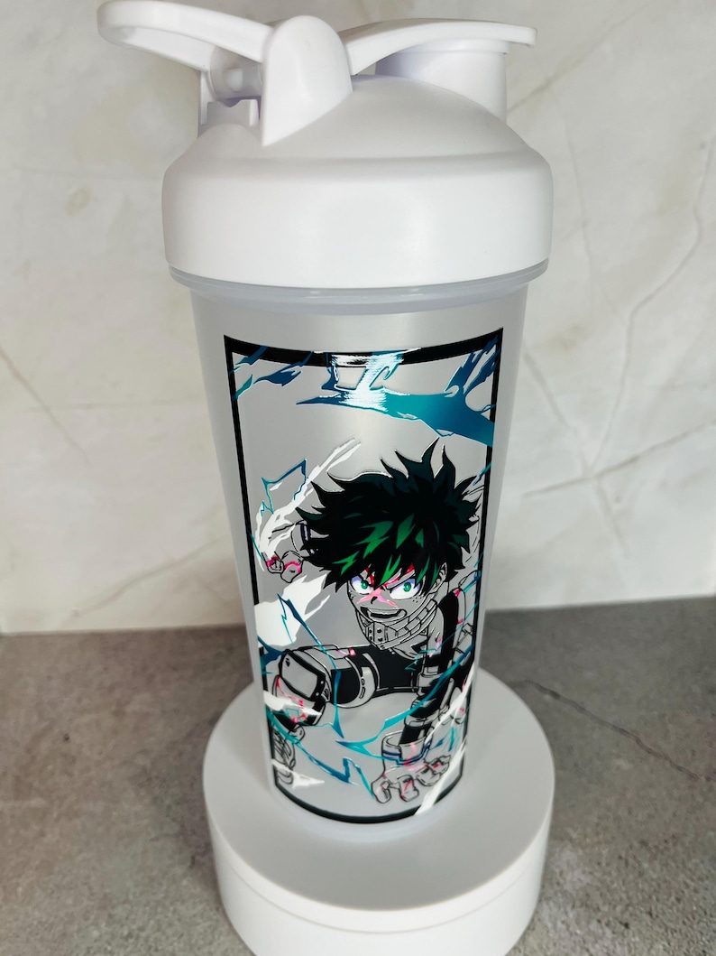 May include: White shaker bottle with a green and black anime character design. The character is surrounded by white and blue lightning bolts. The bottle has a white lid with a black spout.