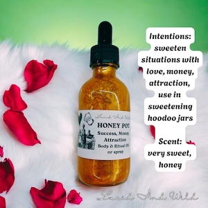 May include: A gold bottle with a clear label that reads "HONEY POT Success, Money, Attraction Body & Ritual Oil or spray". The bottle is sitting on a white fluffy surface with red rose petals. The text "Intentions: sweeten situations with love, money, attraction, use in sweetening hoodoo jars Scent: very sweet, honey Lucid And Wild" is written in black text on a white background.