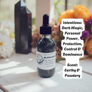 Op de afbeelding: Een heldere glazen fles met een zwarte druppelaar, gevuld met een donkere vloeistof. Het etiket luidt "Black Magik" en vermeldt intenties: Dark Magic, Persoonlijke Macht, Bescherming, Controle & Dominantie. De geur is Aards & Poederig.