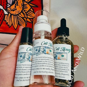 May include: Three clear glass bottles labeled Call Money by Lucid and Wild. The left is a small roller bottle, the center is a spray bottle, and the right is a dropper bottle containing herbs. Each label features a 100 dollar bill graphic.