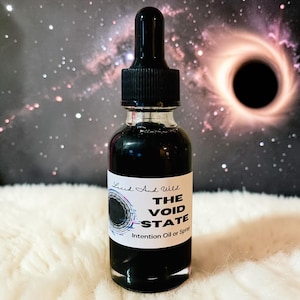 May include: A clear glass bottle with a black liquid and a black dropper. The label reads "Lucid And Wild" and "THE VOID STATE Intention Oil or Spray". The background features a galaxy and a black hole.