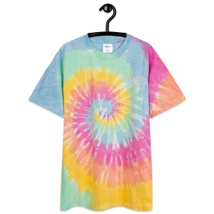 Puede incluir: Una camiseta tie-dye en tonos de azul, verde, amarillo, naranja y rosa con un logotipo blanco "VILLAIN CITY" en la parte delantera.