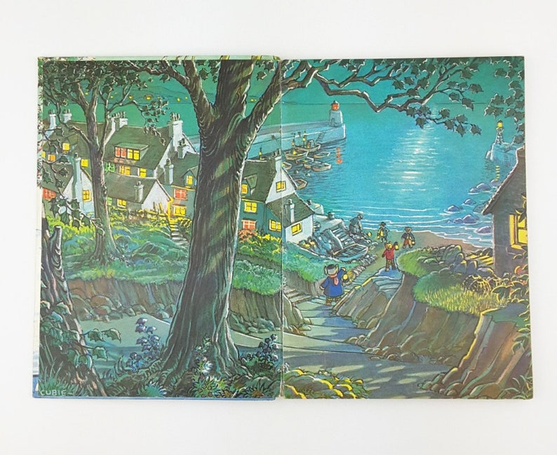 K&ouml;nnte beinhalten: Eine farbenfrohe Illustration einer K&uuml;stenstadt bei Nacht. Die Szene zeigt ein kleines Dorf mit H&auml;usern, B&auml;umen und einem Weg, der zum Wasser f&uuml;hrt. Es gibt Boote im Wasser und einen Leuchtturm in der Ferne. Der Himmel ist dunkelblau mit Sternen und einem hellen Mond.