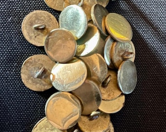 May include: A pile of vintage gold and silver buttons with a shiny finish. The buttons have a shank and are in various sizes.