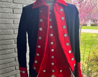 May include: A black and red military jacket with silver buttons. The jacket has a red lining and white cuffs.