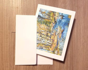 May include: A white card with a colorful painting of a forest scene with a stream running through it. The trees are a mix of green, yellow, and brown, and the stream is a bright blue. The card is blank on the back.