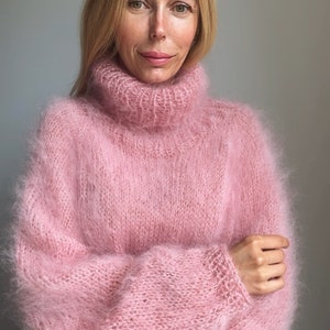 May include: A soft, pink, fuzzy turtleneck sweater with long sleeves.