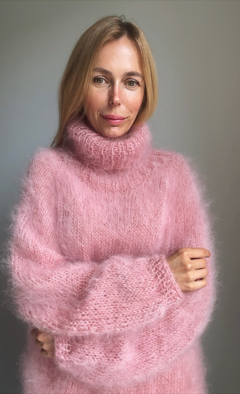 May include: A soft, pink, fuzzy turtleneck sweater with long sleeves.