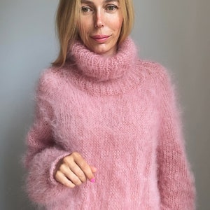 May include: A soft, pink, fuzzy turtleneck sweater.