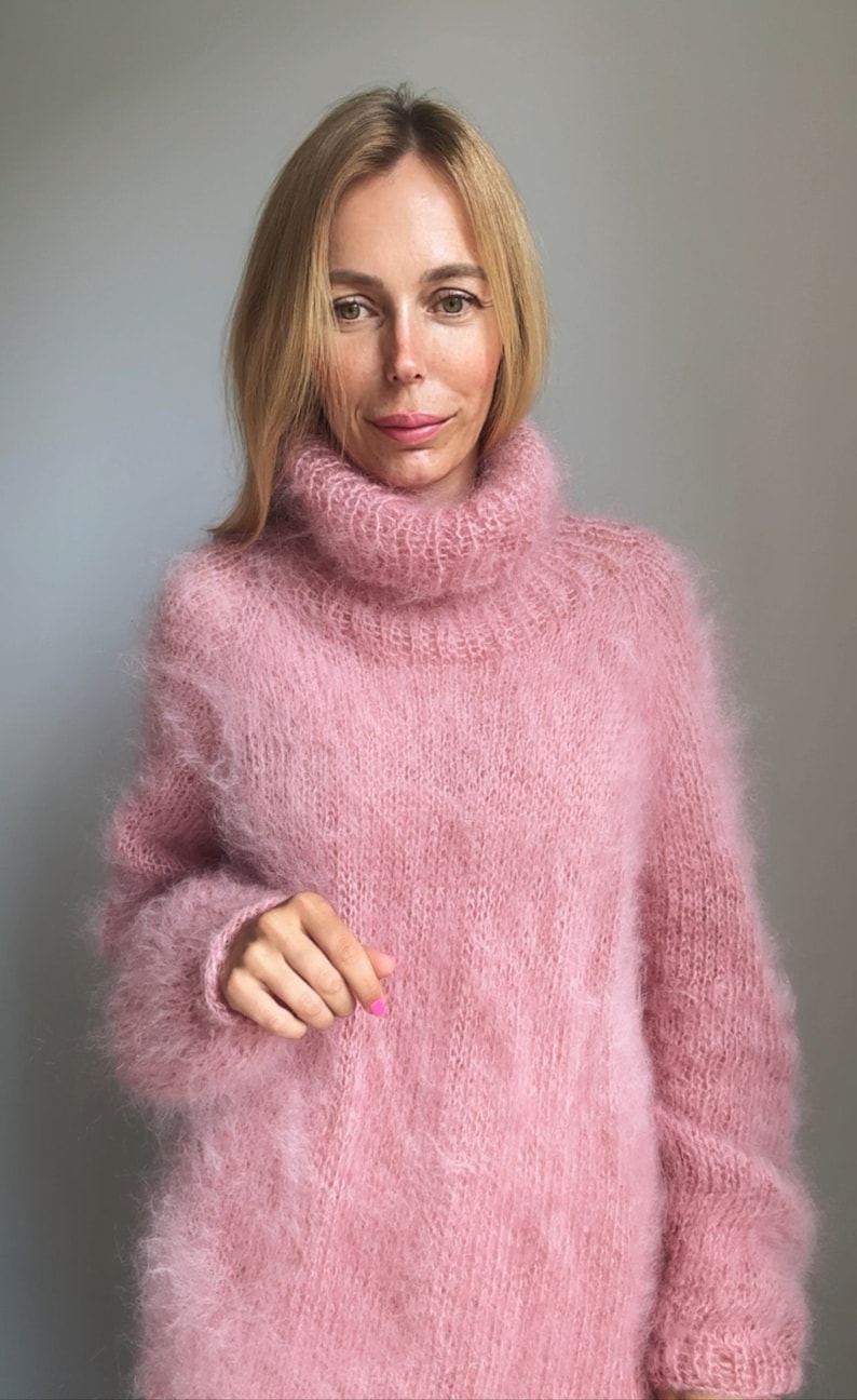 May include: A soft, pink, fuzzy turtleneck sweater.