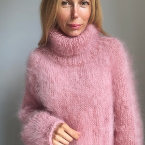 May include: A soft, pink, fuzzy turtleneck sweater with long sleeves.