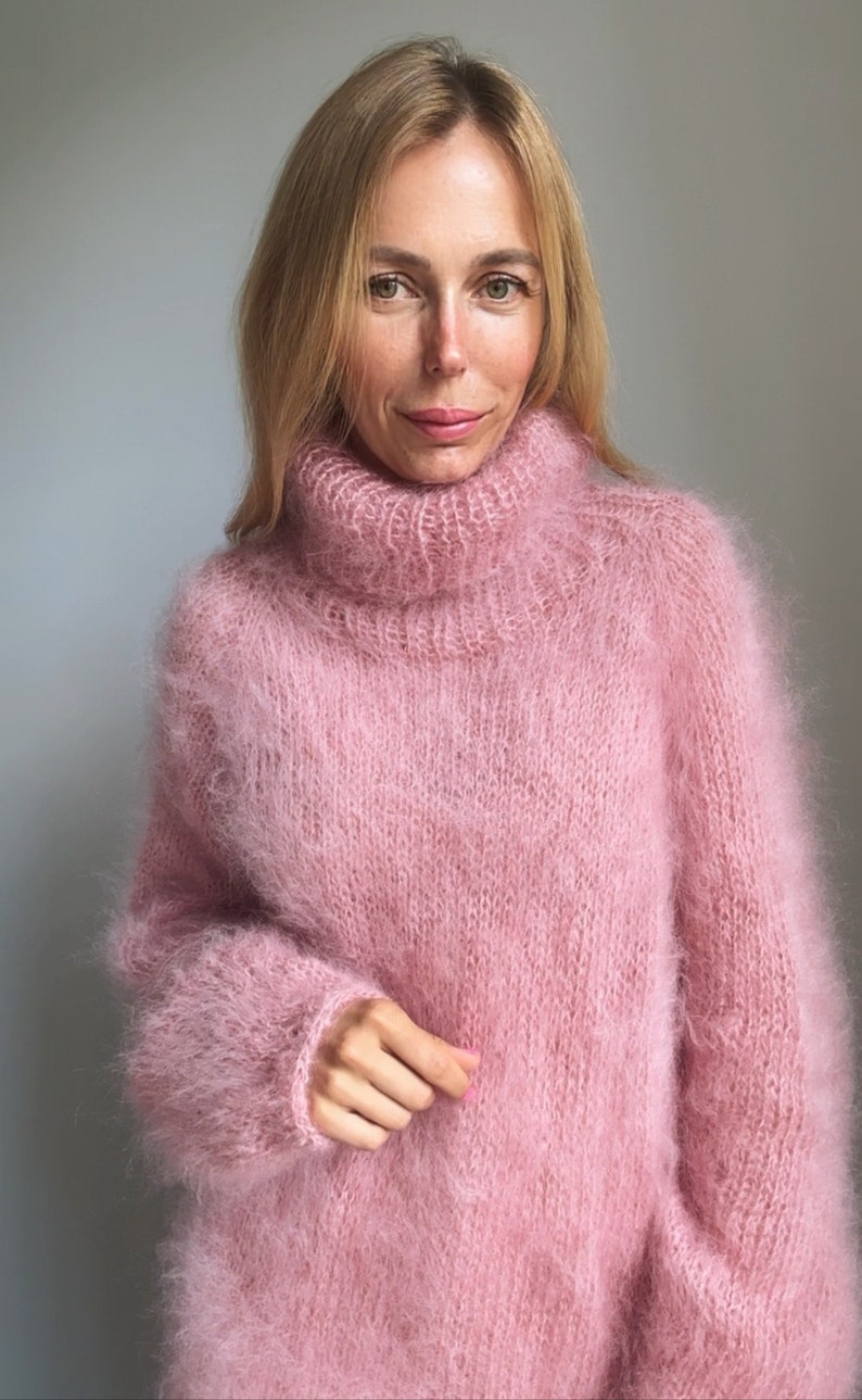 May include: A soft, pink, fuzzy turtleneck sweater with long sleeves.