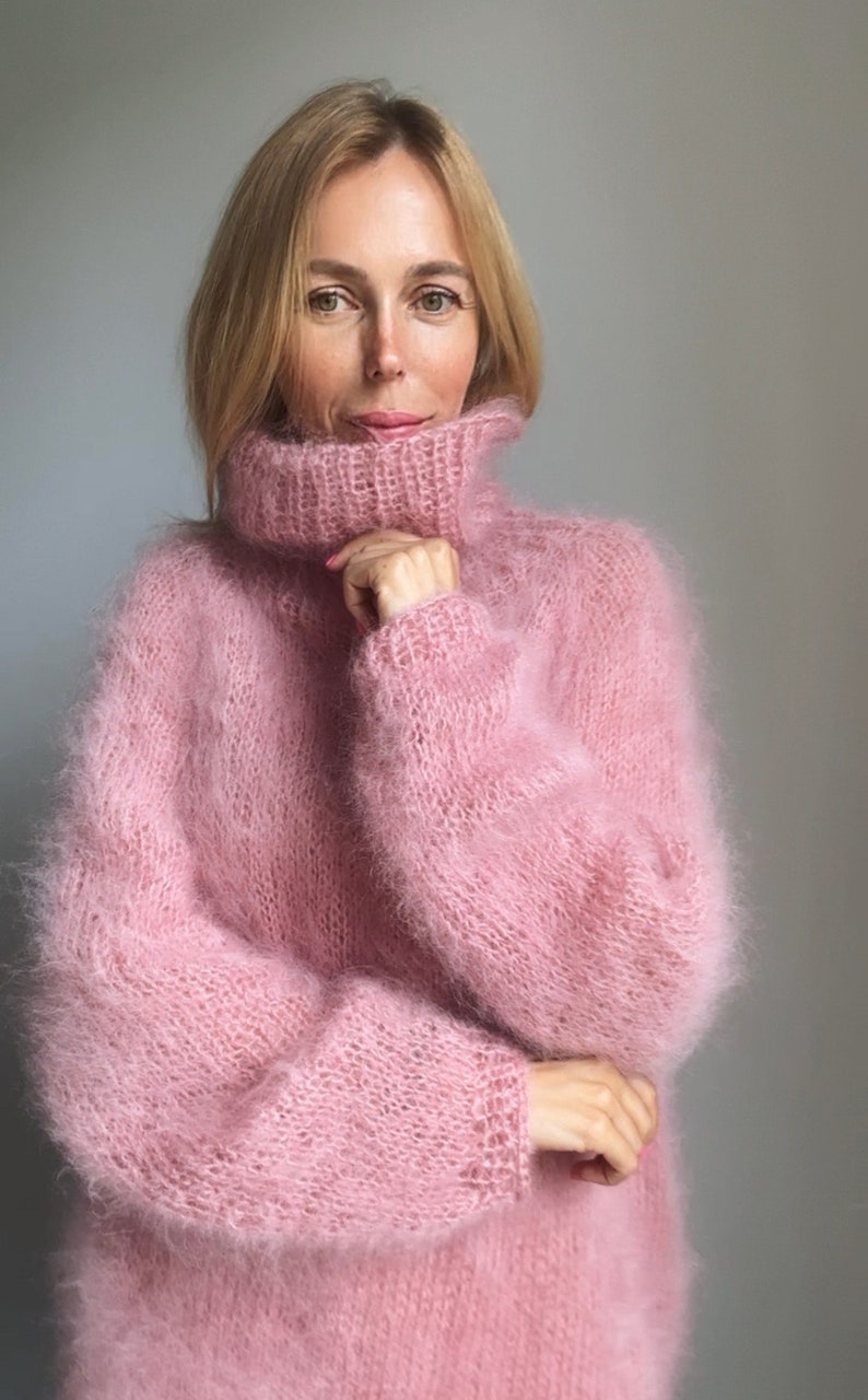 May include: A soft, pink, fuzzy turtleneck sweater with long sleeves.